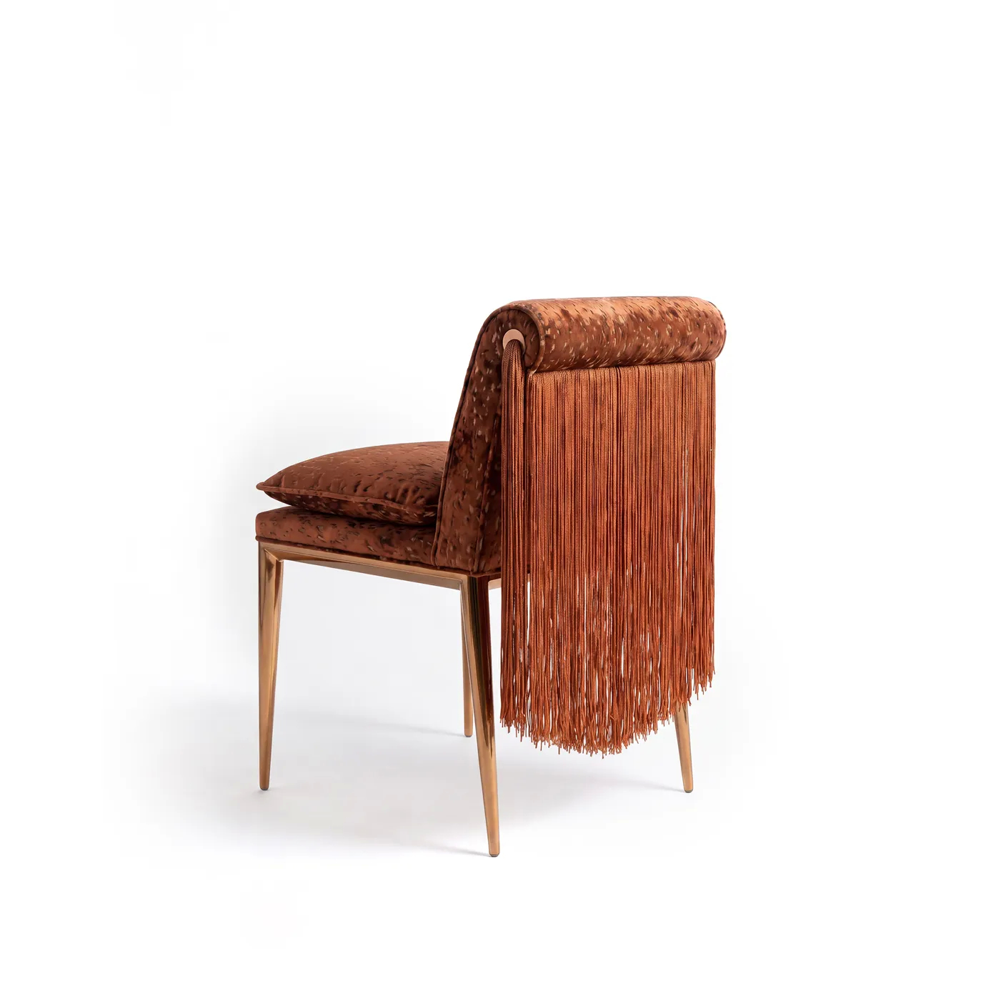Side view of Lucienne dining chair by KOKET showing cascading fringe from the rolled back and the brass tassel detail.