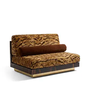 Eileen lounge chair by KOKET at an angle, tiger-print velvet with brown bolster on walnut burl plinth and polished brass base.