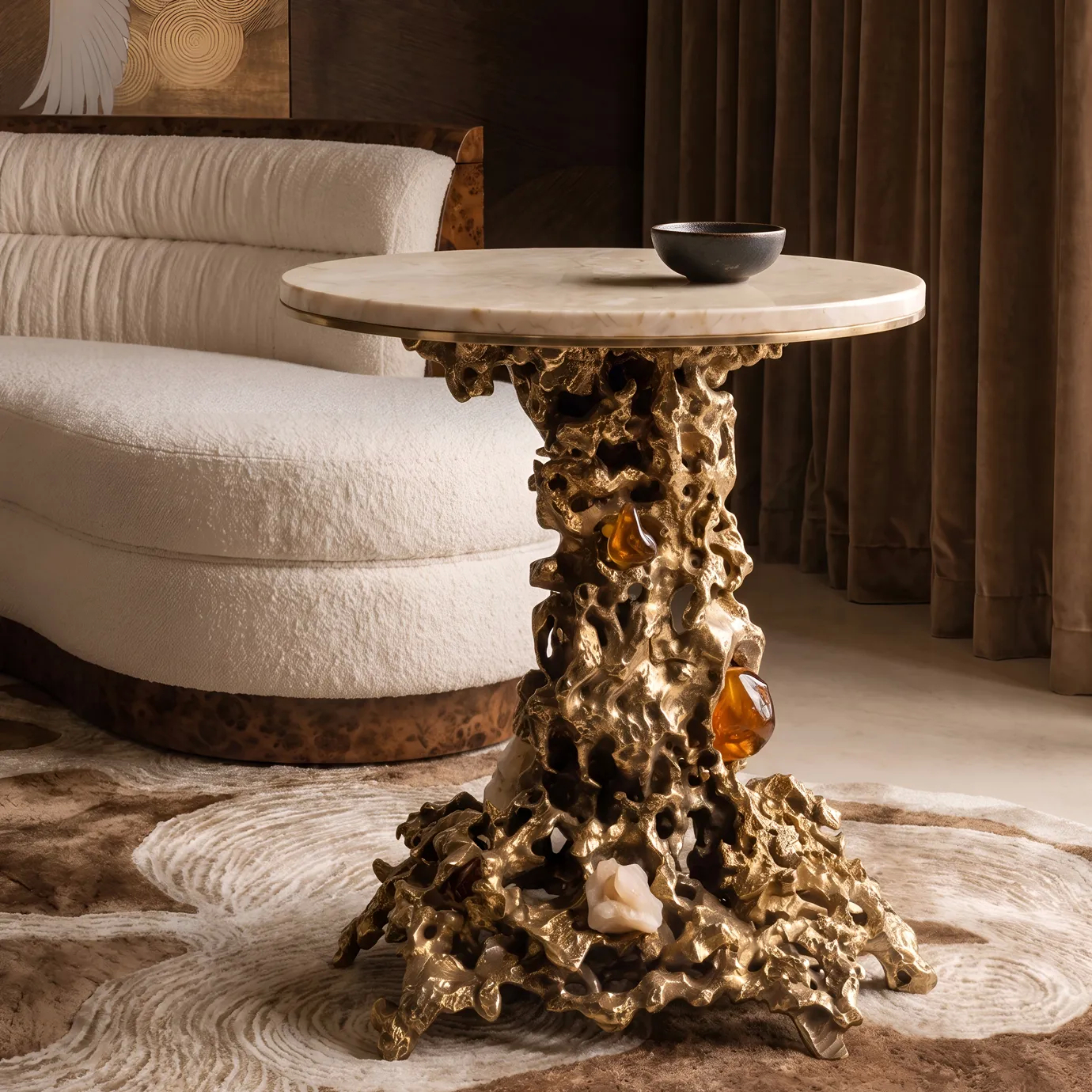 Empress side table by KOKET in a warm interior with crane-motif art, cream marble top on a sand-cast brass base.