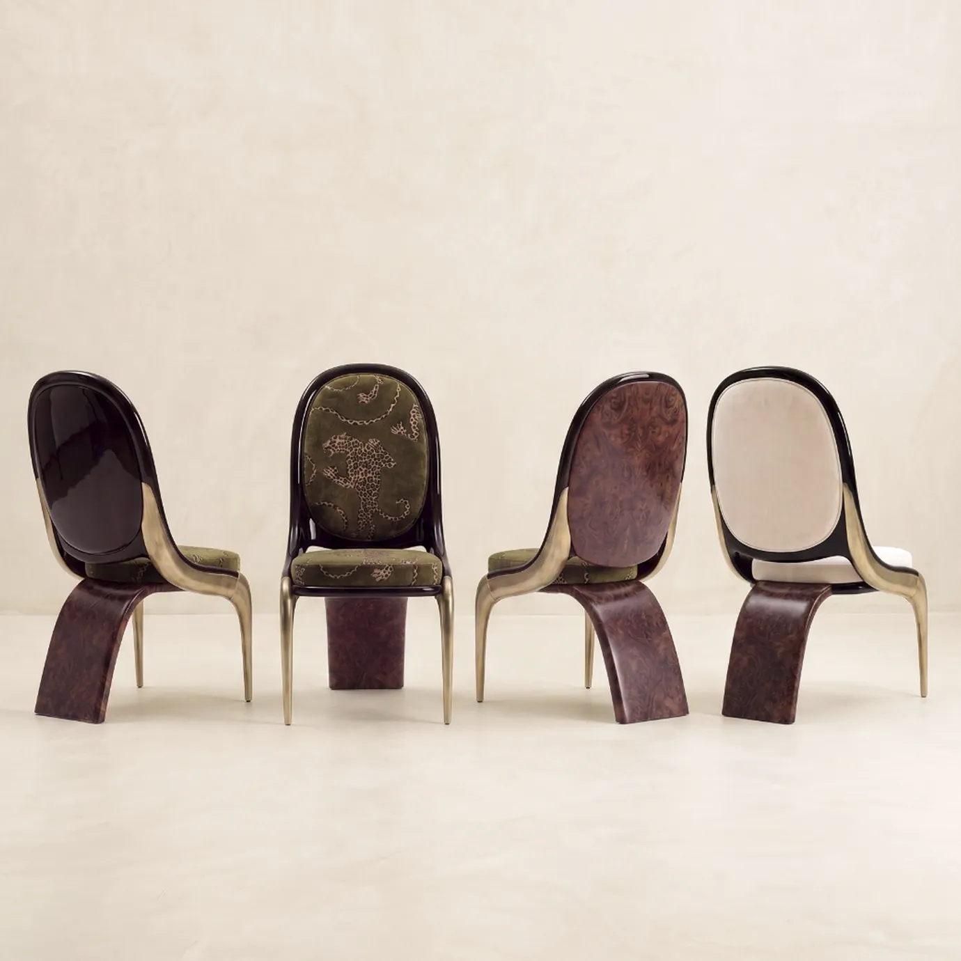 Four Gabrielle dining chairs by KOKET in a row, olive leopard-print and cream velvet, black lacquer, brass and walnut burl.