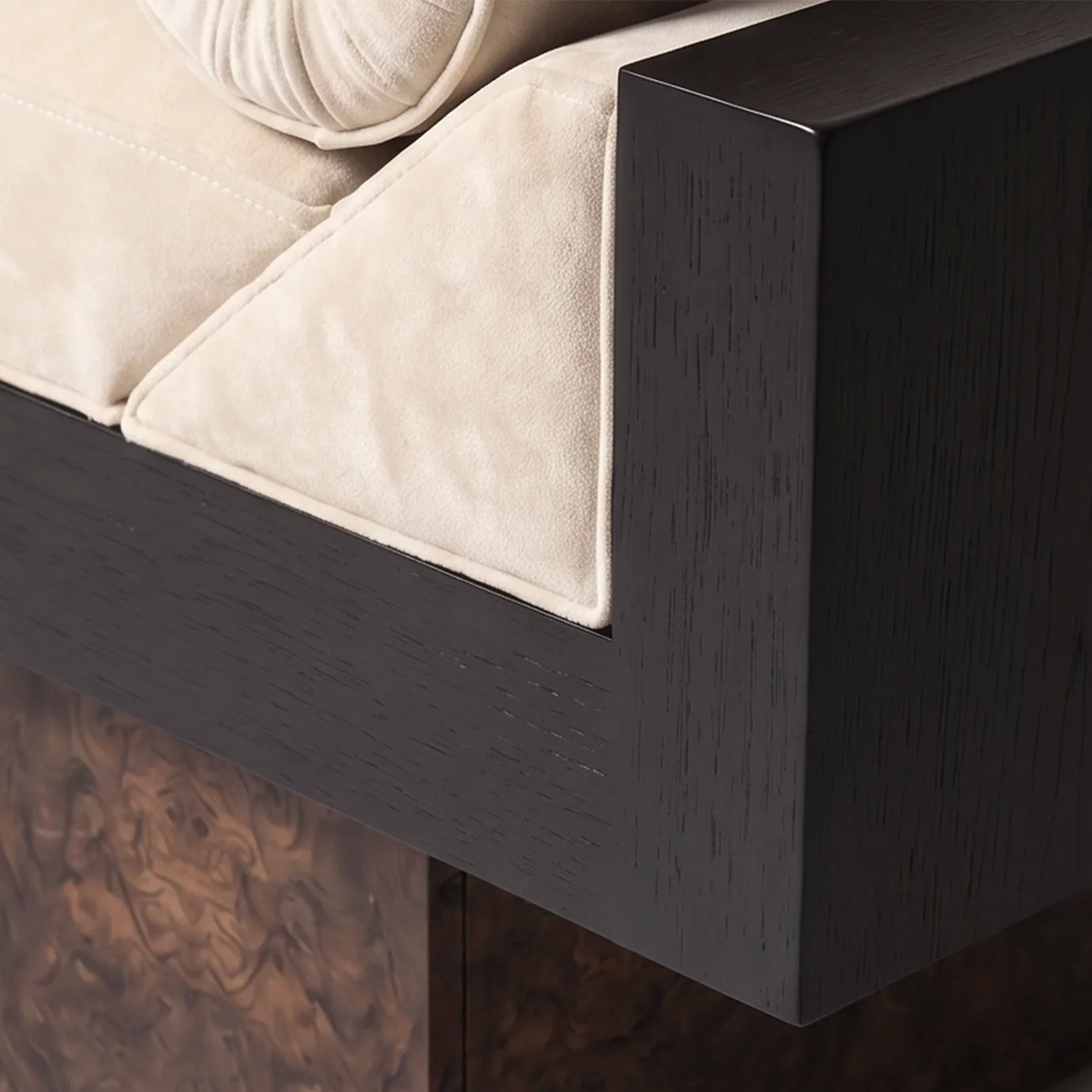 Detail of Lola bench by KOKET, cream velvet seat and piping against the black stained oak frame over a walnut root plinth.