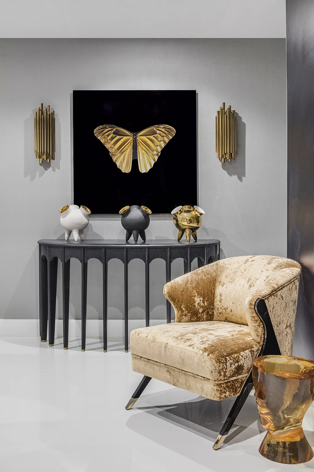 Labor of Love: A stylish room featuring a Naomi chair in golden velvet, a black table, and decorative sculptures.