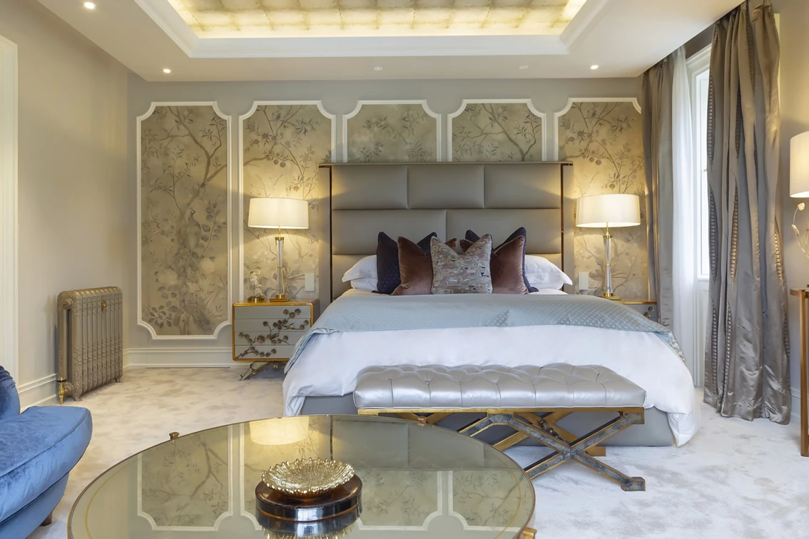 Broughshane features a modern luxury bedroom with a unique mirrored headboard design, elegant side tables, and decorative lighting.