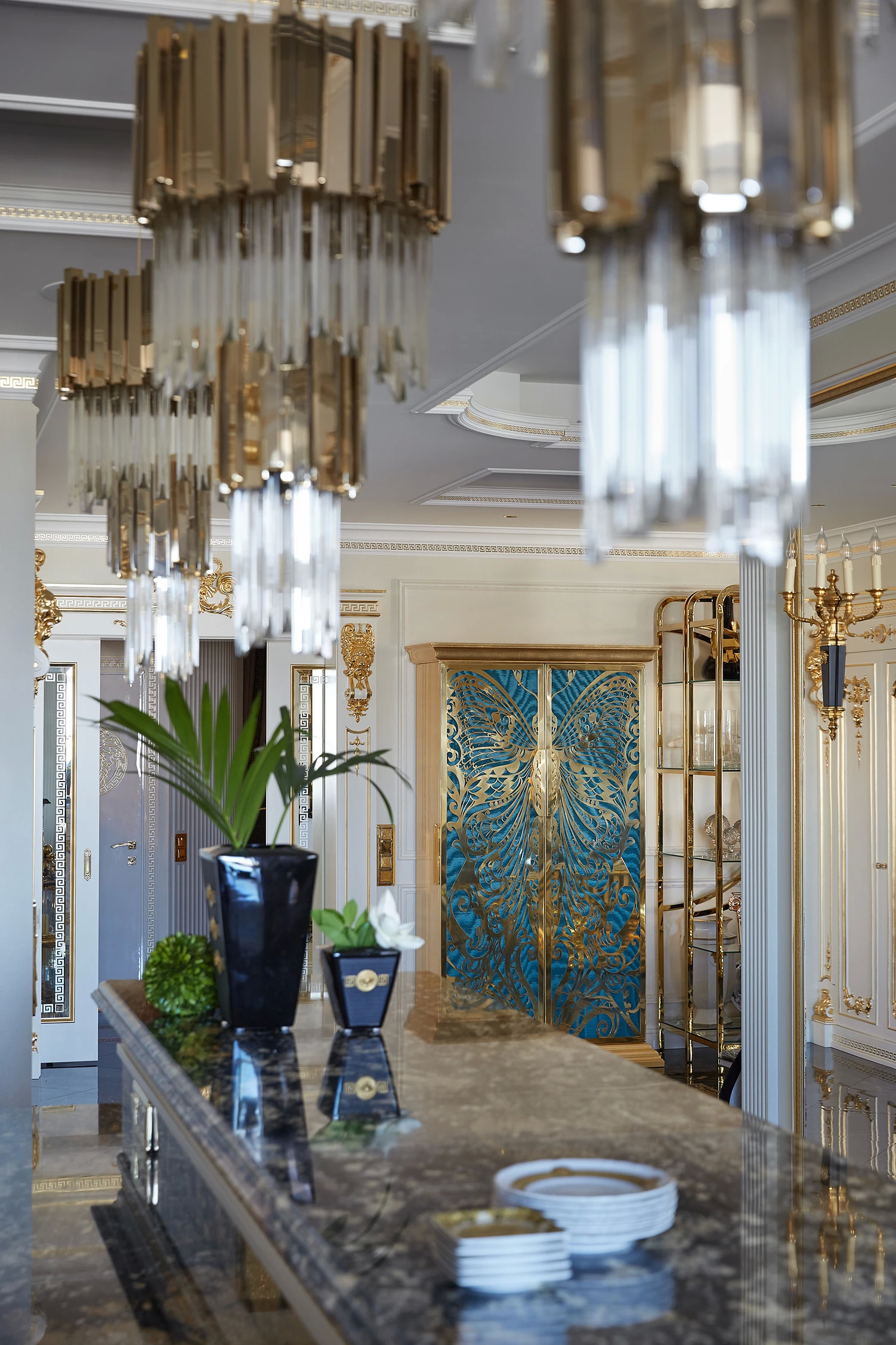 Koket's The Whimsical Home Of Gia Eradzy features stunning Empire Chandeliers and an ornate blue and gold door.