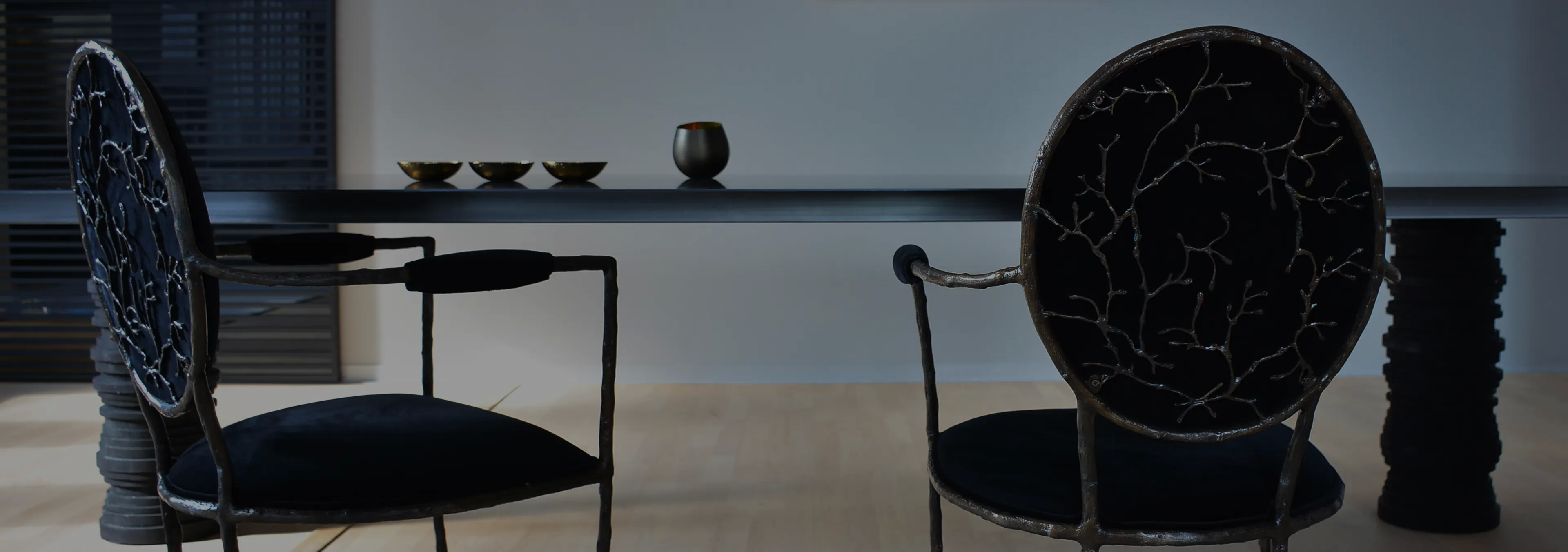 Labor of Love: Two Naomi chairs with golden velvet upholstery and black legs, with a decorative glass vase.