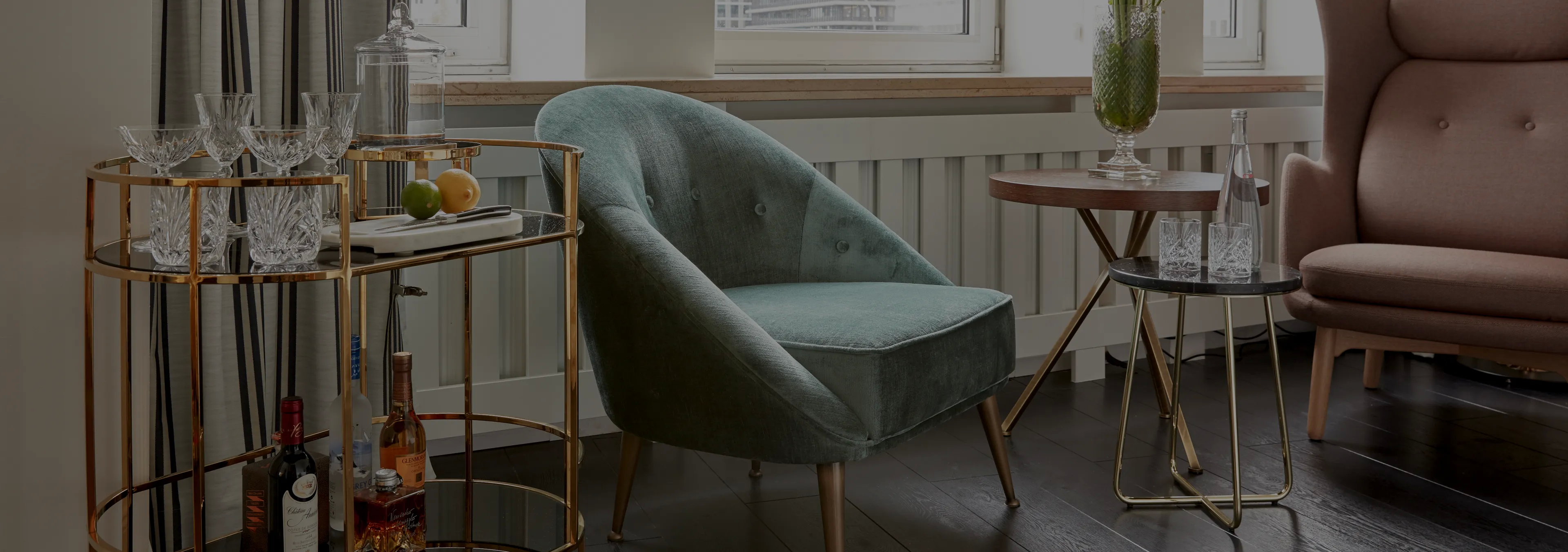 Labor of Love: Two Naomi chairs with golden velvet upholstery and black legs, with a decorative glass vase.