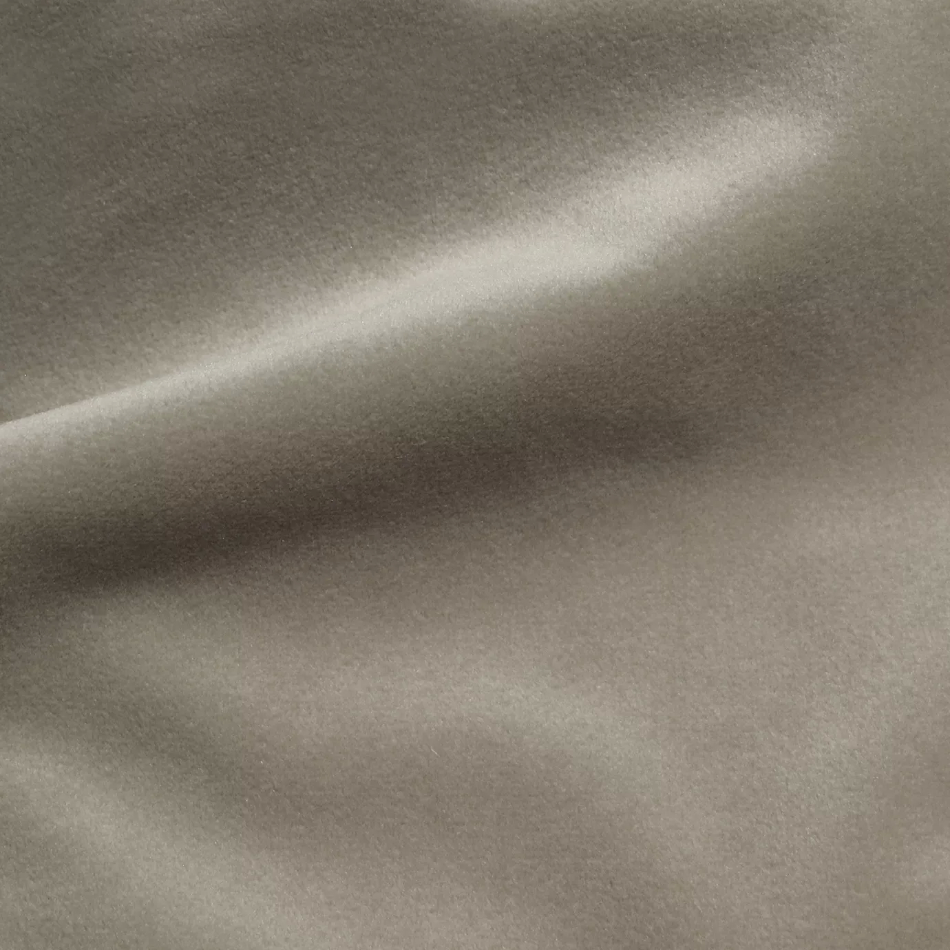 Elegant close-up of a Cozy Velvet Simply Taupe fabric swatch in a simple and sophisticated taupe tone, showcasing its smooth texture and the delicate folds that highlight its depth.