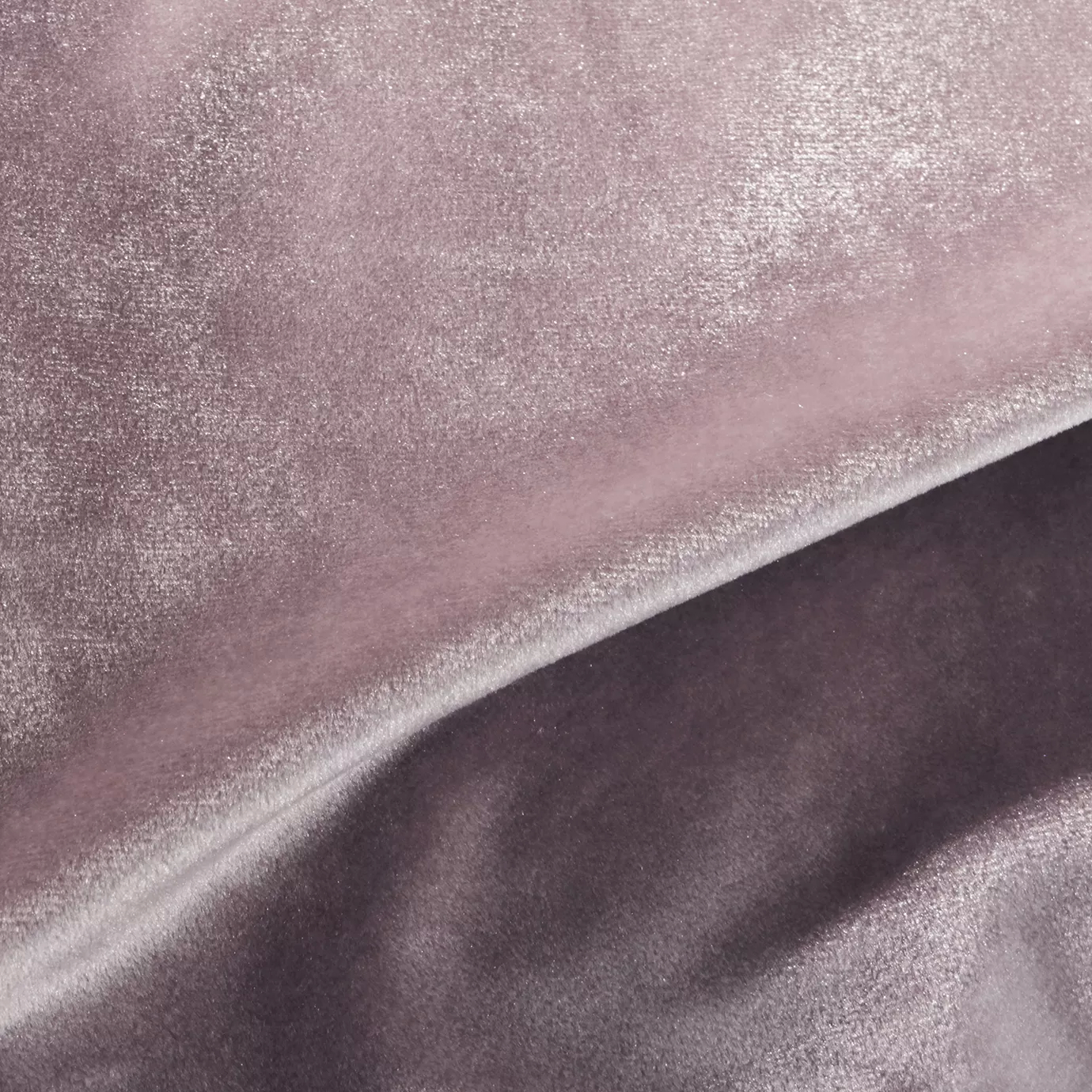 Elegant close-up of a Silky Velvet 402 fabric swatch in a luminous and soft antique rose tone, showcasing its smooth texture and the delicate folds that highlight its romantic and silky sheen.