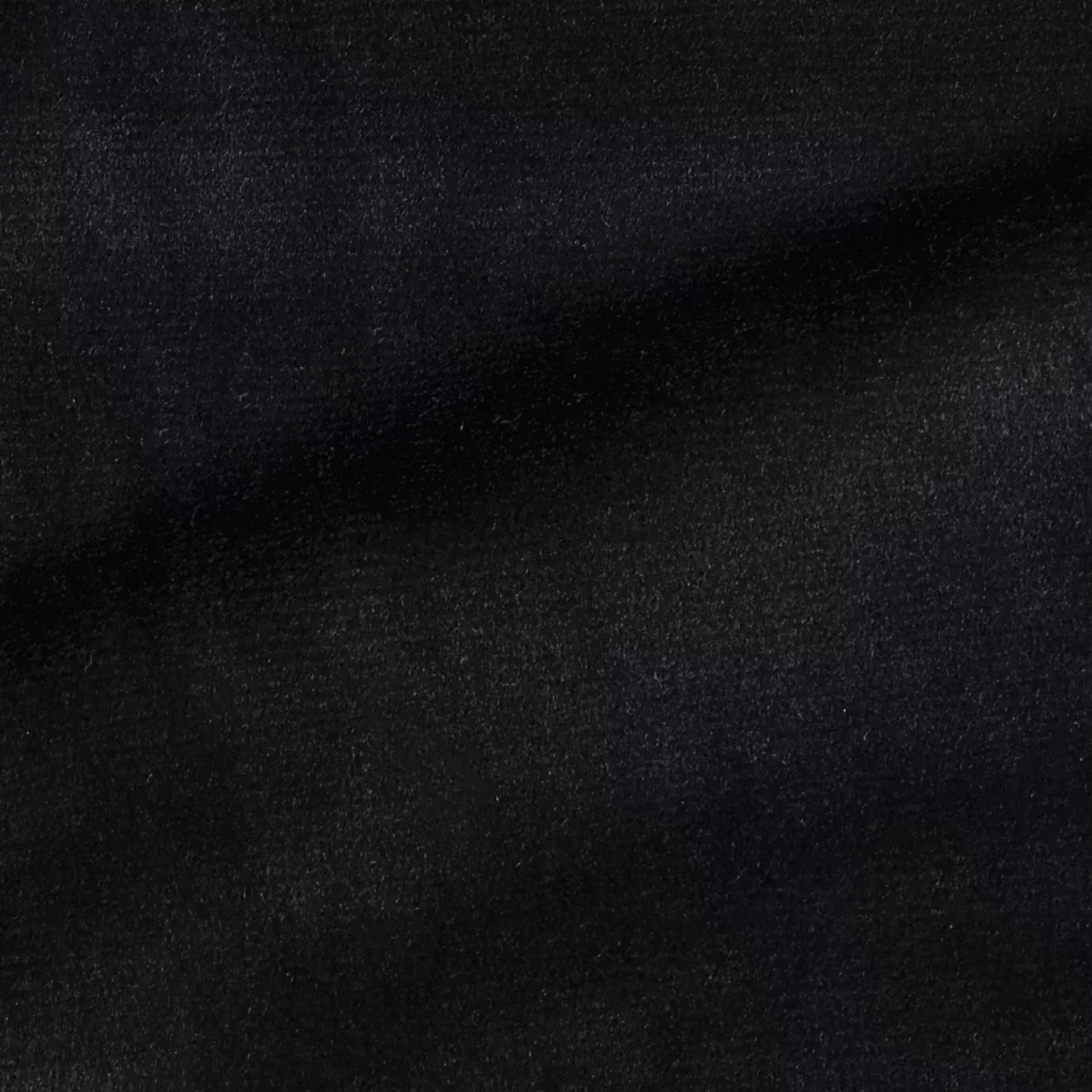 Elegant close-up of a Radiance Velvet Bluish Black fabric swatch in a deep and sophisticated bluish-black tone, showcasing its velvety texture and the gentle folds that highlight its intense and welcoming elegance.