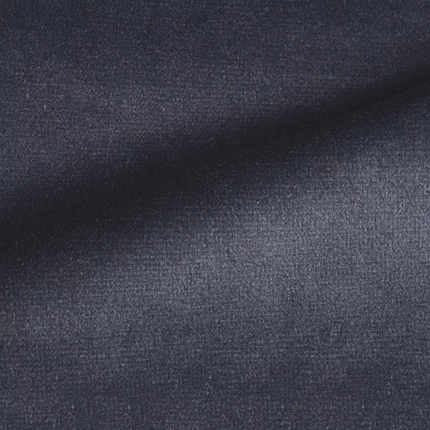 Elegant close-up of a Radiance Velvet Deep Navy fabric swatch in a deep and sophisticated navy blue tone, showcasing its velvety texture and the gentle folds that highlight its classic and welcoming elegance.