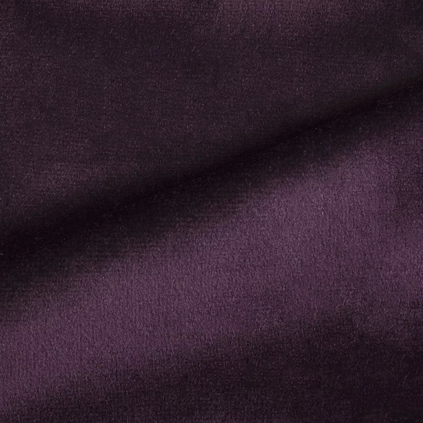 Elegant close-up of a Radiance Velvet Deep Violet fabric swatch in a deep and sophisticated violet tone, showcasing its velvety texture and the gentle folds that highlight its rich and welcoming elegance.