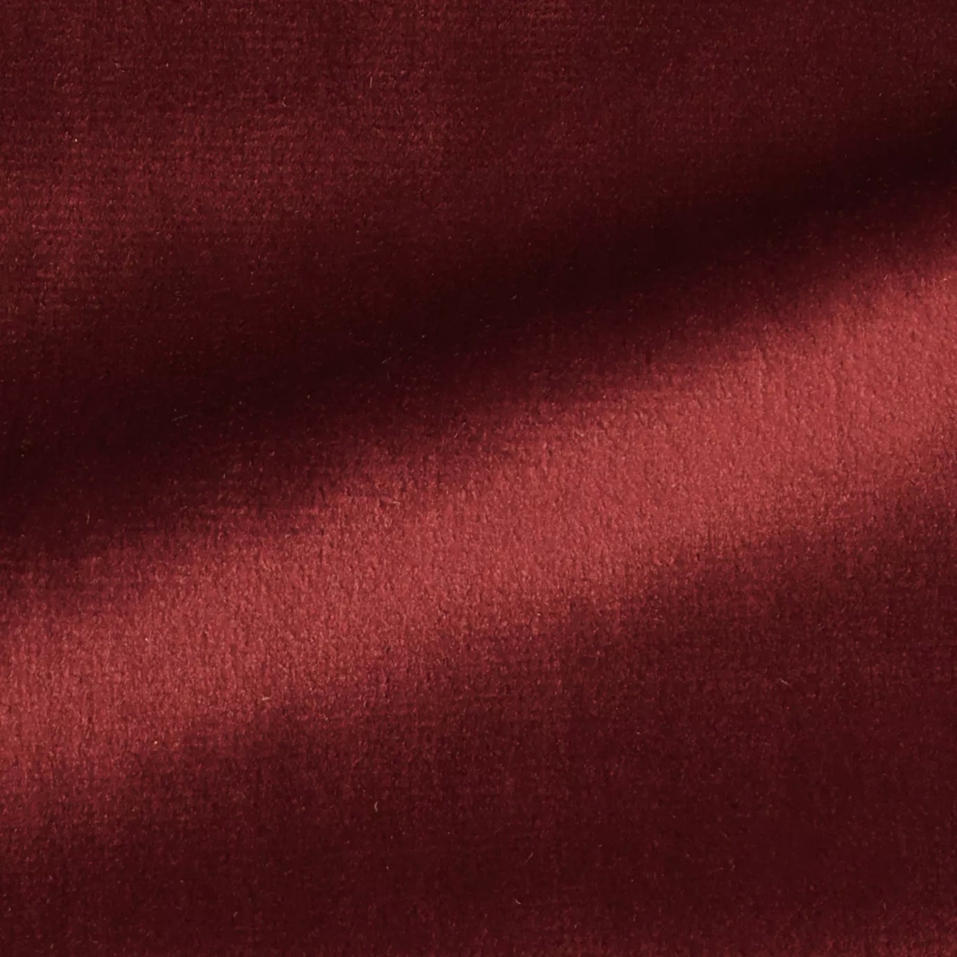 Elegant close-up of a Radiance Velvet Lipstick Red fabric swatch in a vibrant and sophisticated red tone, showcasing its velvety texture and the gentle folds that highlight its vibrant and welcoming elegance.