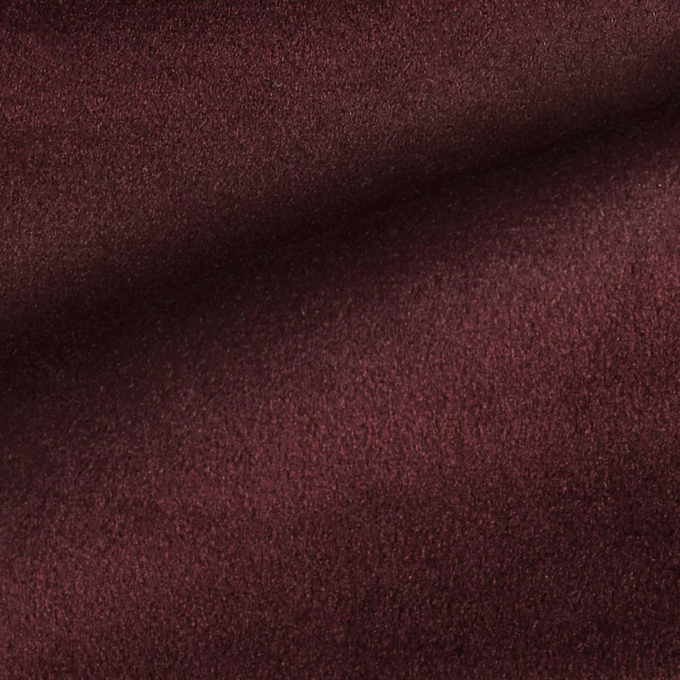 Elegant close-up of a Radiance Velvet Sirah fabric swatch in a rich and sophisticated burgundy tone, showcasing its velvety texture and the gentle folds that highlight its deep and welcoming elegance.