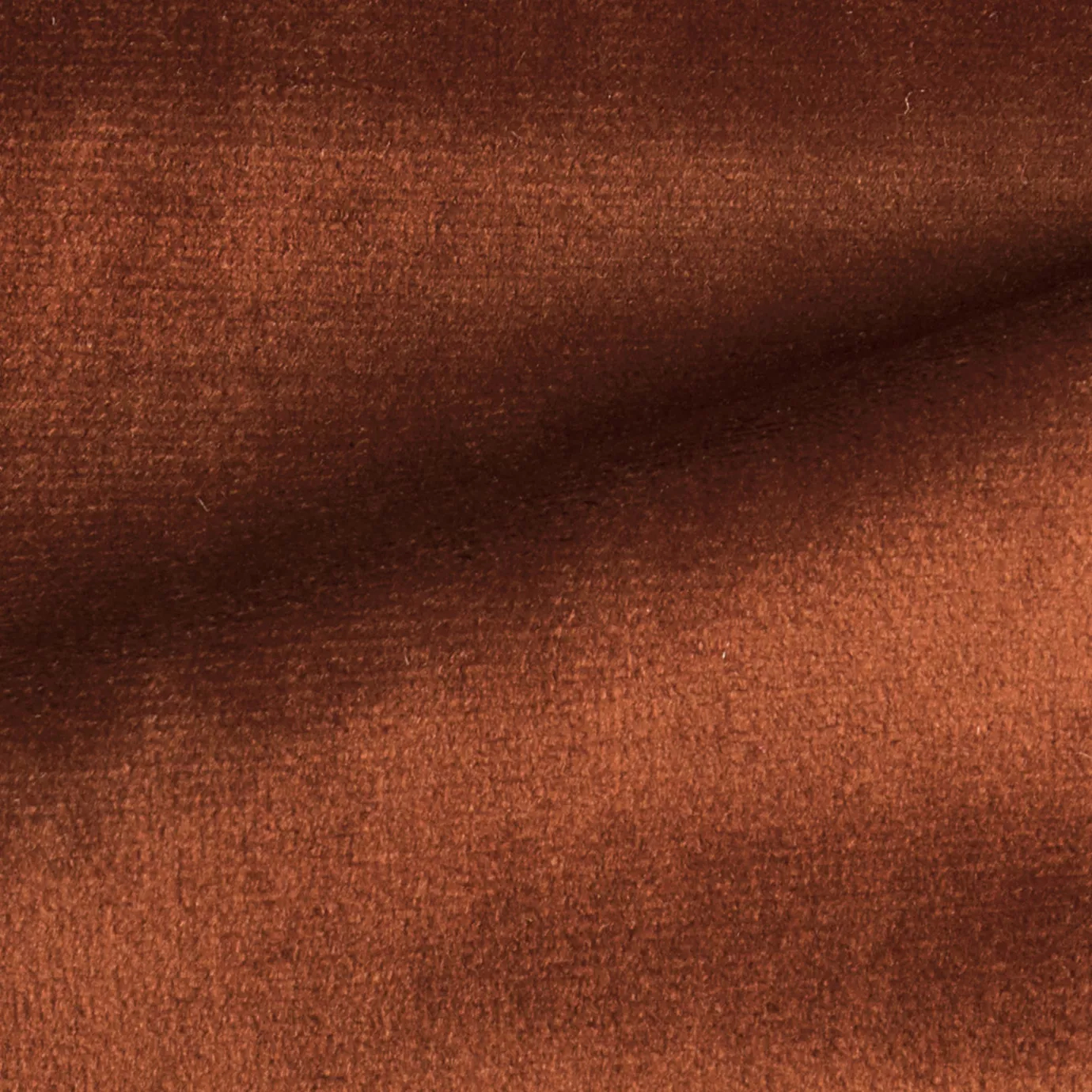 Elegant close-up of a Radiance Velvet Terracotta fabric swatch in a warm and earthy terracotta tone, showcasing its velvety texture and the gentle folds that highlight its welcoming and natural elegance.