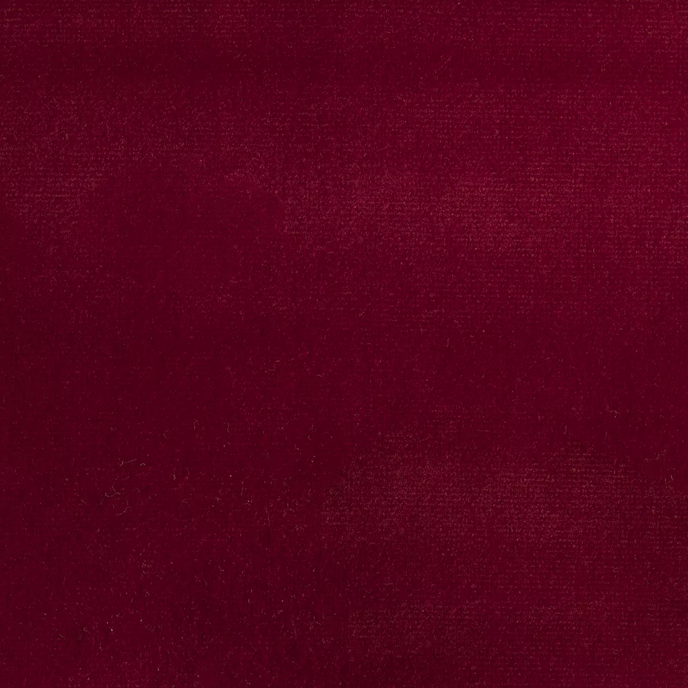 Elegant close-up of a Paris Velvet Deep Red fabric swatch in a deep and sophisticated red tone, showcasing its velvety texture and a subtle sheen that gives it a feeling of comfort and intense elegance.