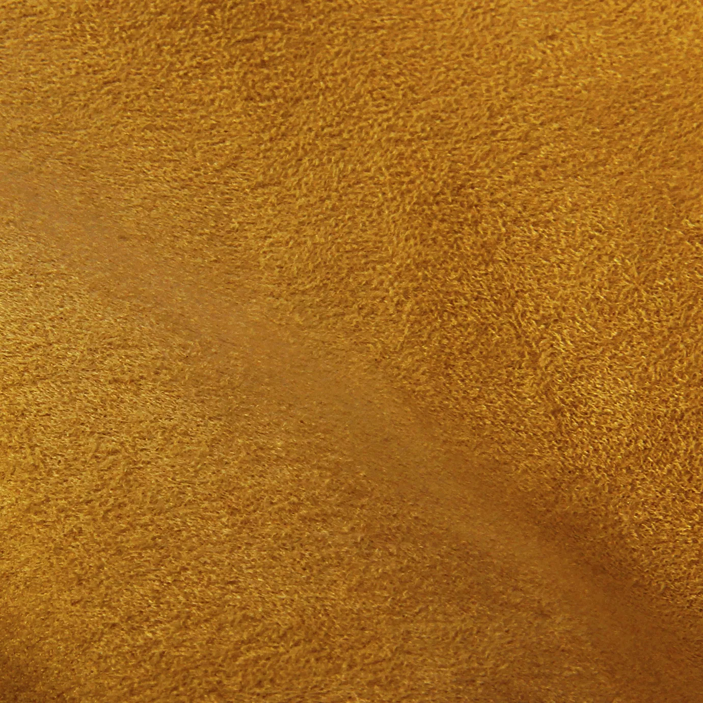 Soft close-up of an Ultra Suede Amber Yellow fabric swatch in a warm and rich amber yellow tone, showcasing its delicate texture and a gentle touch that gives it a feeling of comfort and natural elegance.