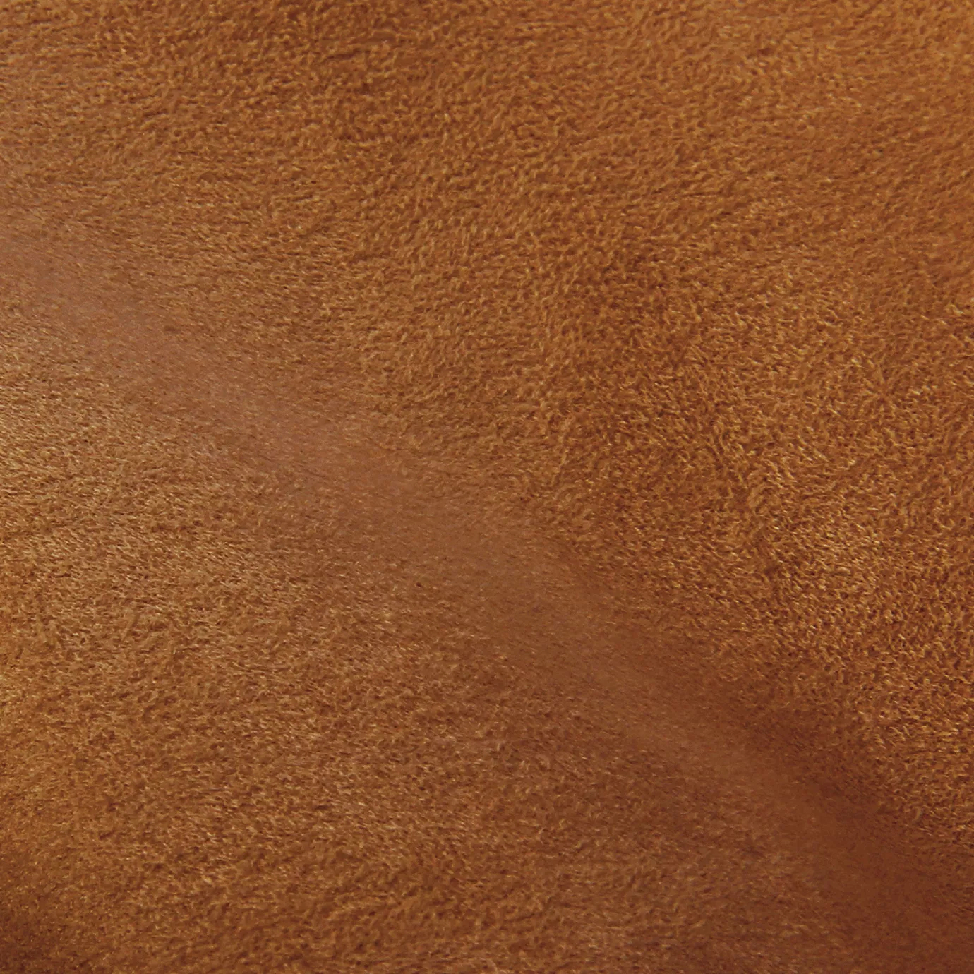 Soft close-up of an Ultra Suede Apricot Orange fabric swatch in a warm and soft apricot orange tone, showcasing its delicate texture and a gentle touch that gives it a feeling of comfort and natural elegance.