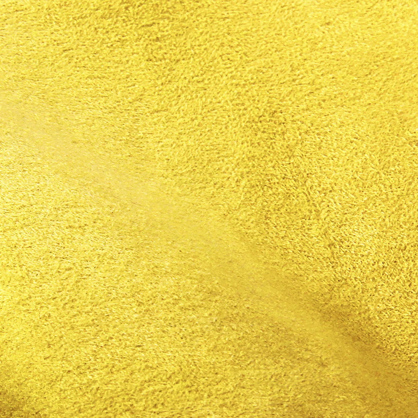 Soft close-up of an Ultra Suede Blazing Yellow fabric swatch in a bright and vibrant yellow tone, showcasing its delicate texture and a gentle touch that gives it a feeling of comfort and modern elegance.