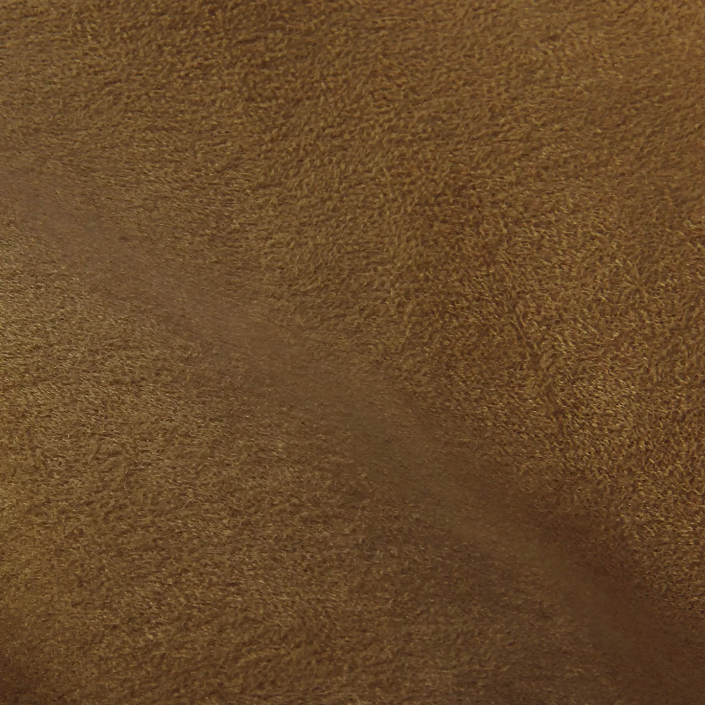 Soft close-up of an Ultra Suede Brown Sugar fabric swatch in a warm and rich brown sugar tone, showcasing its delicate texture and a gentle touch that gives it a feeling of comfort and natural elegance.
