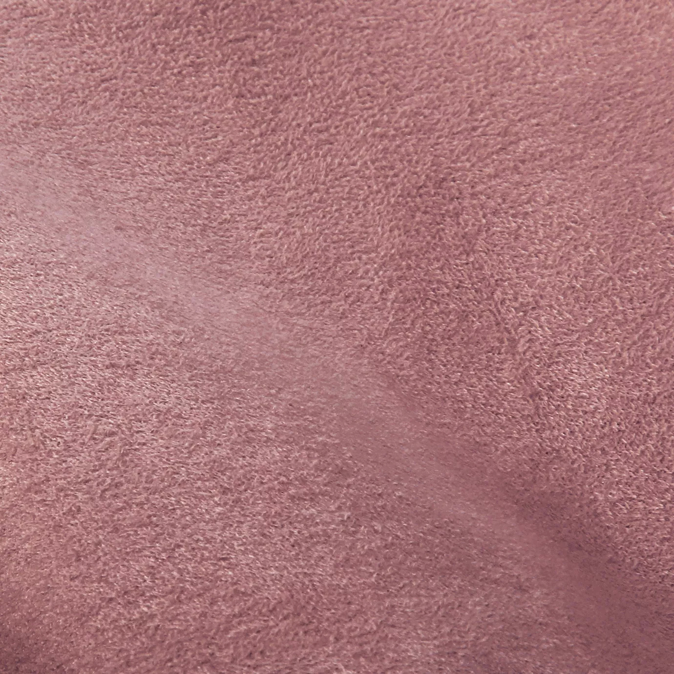 Soft close-up of an Ultra Suede Candy Pink fabric swatch in a sweet and soft pink tone, showcasing its delicate texture and a gentle touch that gives it a feeling of comfort and delicate elegance.