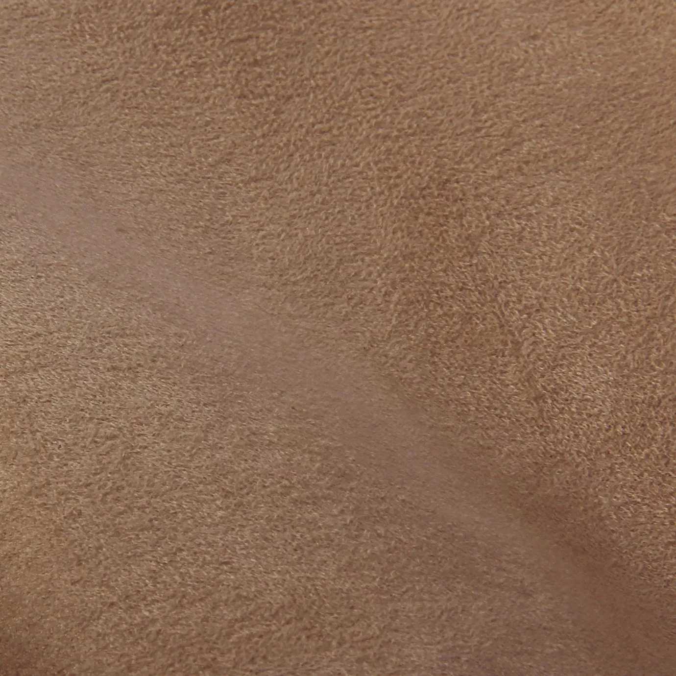 Soft close-up of an Ultra Suede Caramel fabric swatch in a warm and rich caramel tone, showcasing its delicate texture and a gentle touch that gives it a feeling of comfort and natural elegance.