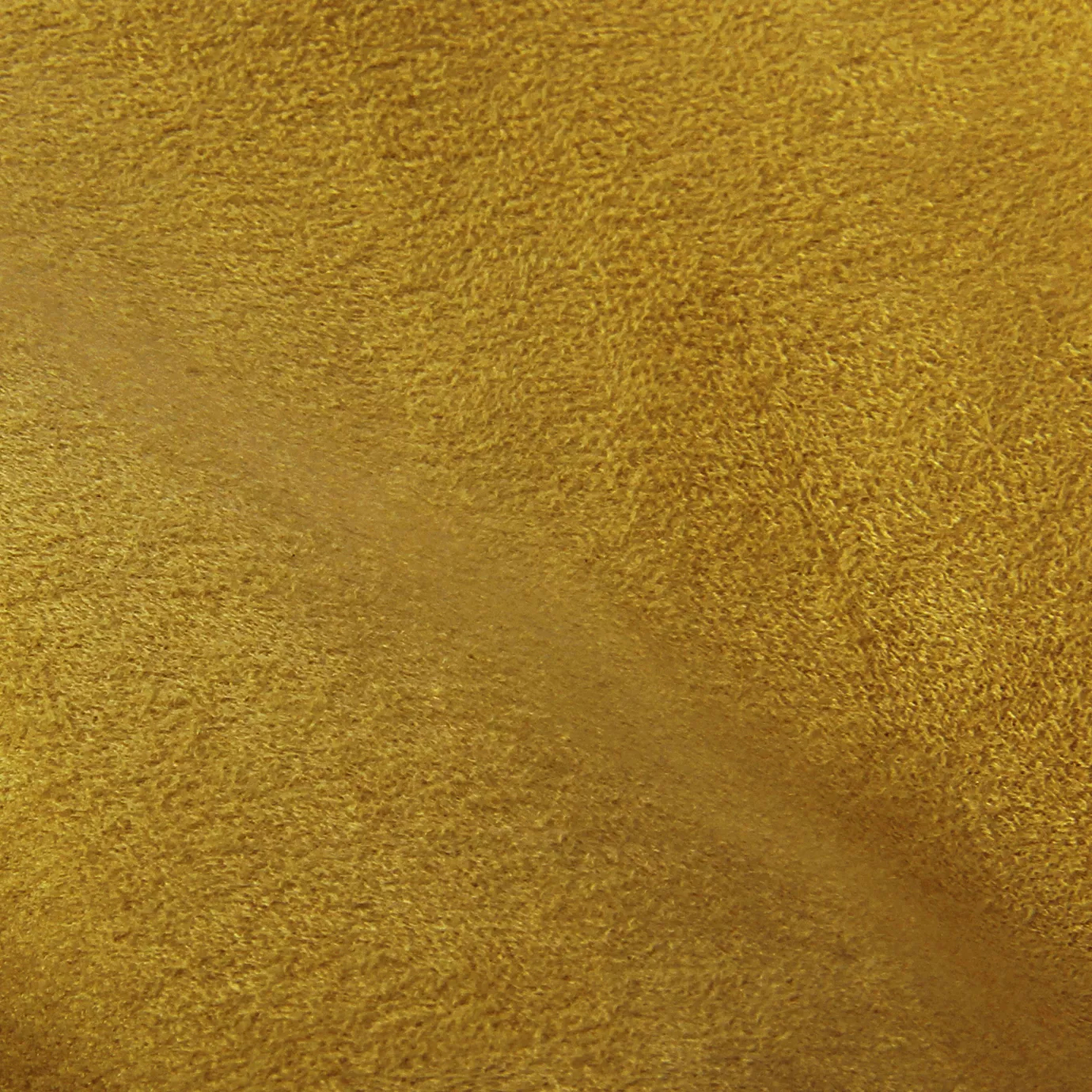 Soft close-up of an Ultra Suede Ochre fabric swatch in a warm and natural ochre tone, showcasing its delicate texture and a gentle touch that gives it a feeling of comfort and understated elegance.