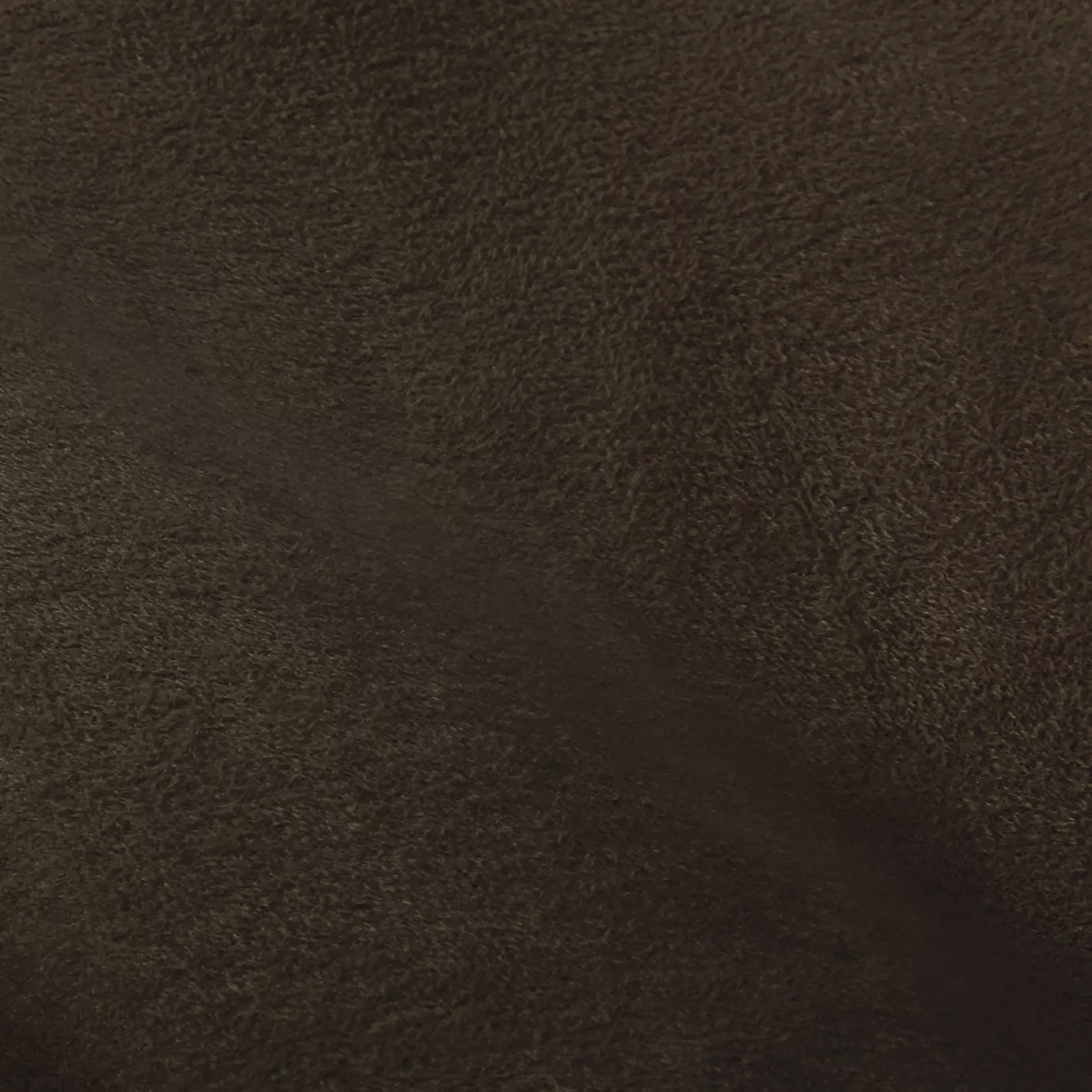 Soft close-up of an Ultra Suede Pine Cone fabric swatch in a warm and natural pine cone brown tone, showcasing its delicate texture and a gentle touch that gives it a feeling of comfort and understated elegance.