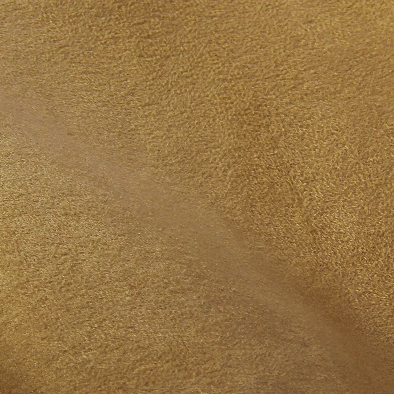 Soft close-up of an Ultra Suede Sand fabric swatch in a warm and natural sand beige tone, showcasing its delicate texture and a gentle touch that gives it a feeling of comfort and understated elegance.