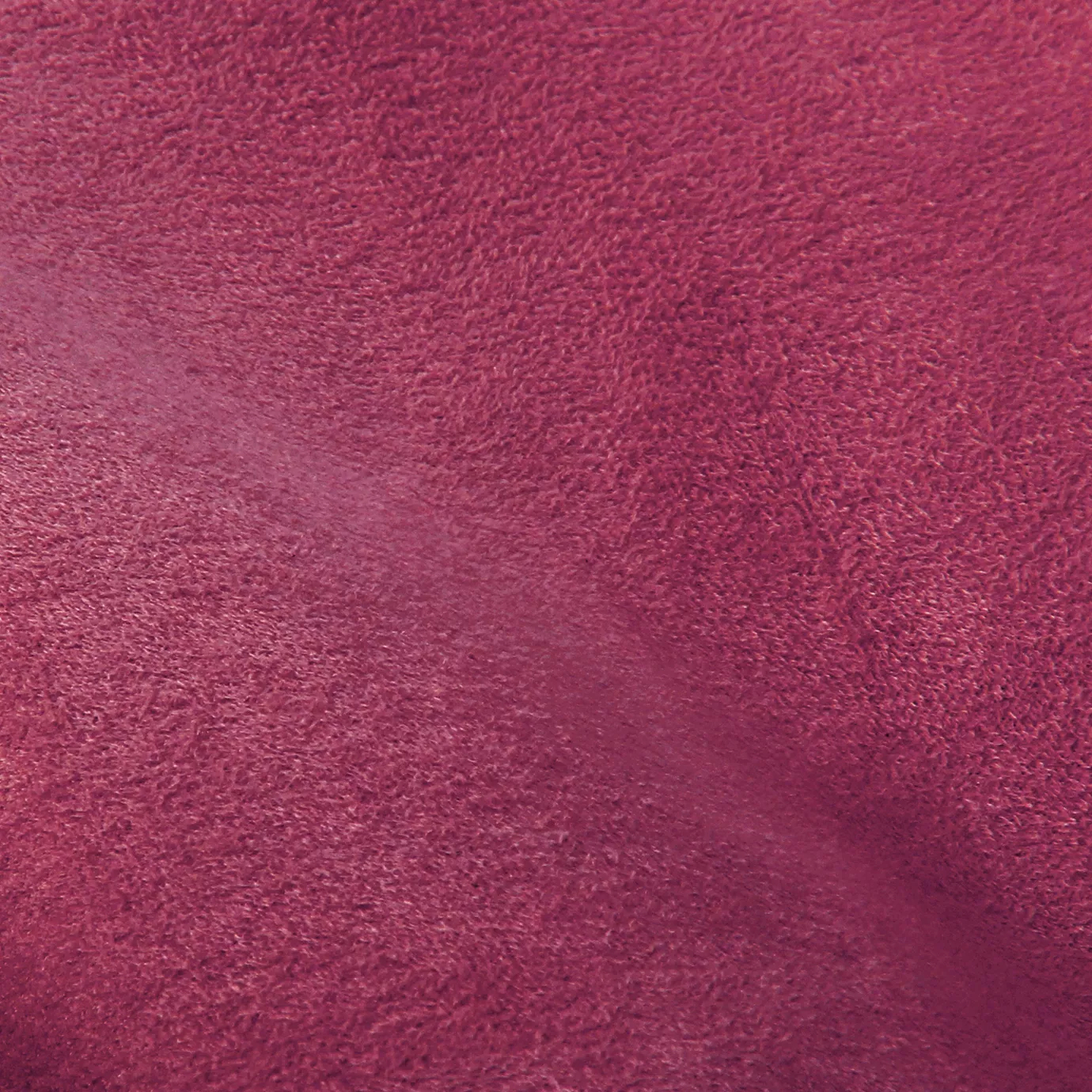 Soft close-up of an Ultra Suede Shocking Pink fabric swatch in a vibrant and bold shocking pink tone, showcasing its delicate texture and a gentle touch that gives it a feeling of comfort and modern elegance.