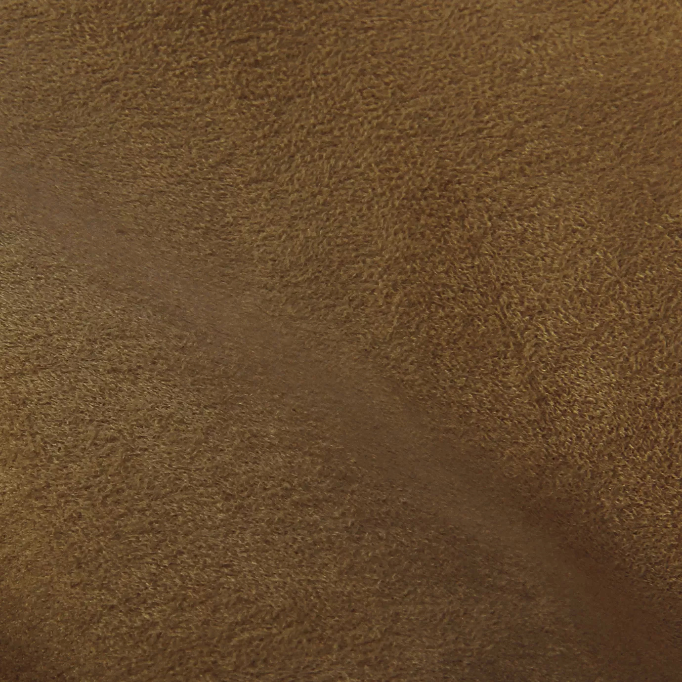 Soft close-up of an Ultra Suede Tobacco Brown fabric swatch in a warm and rich tobacco brown tone, showcasing its delicate texture and a gentle touch that gives it a feeling of comfort and natural elegance.