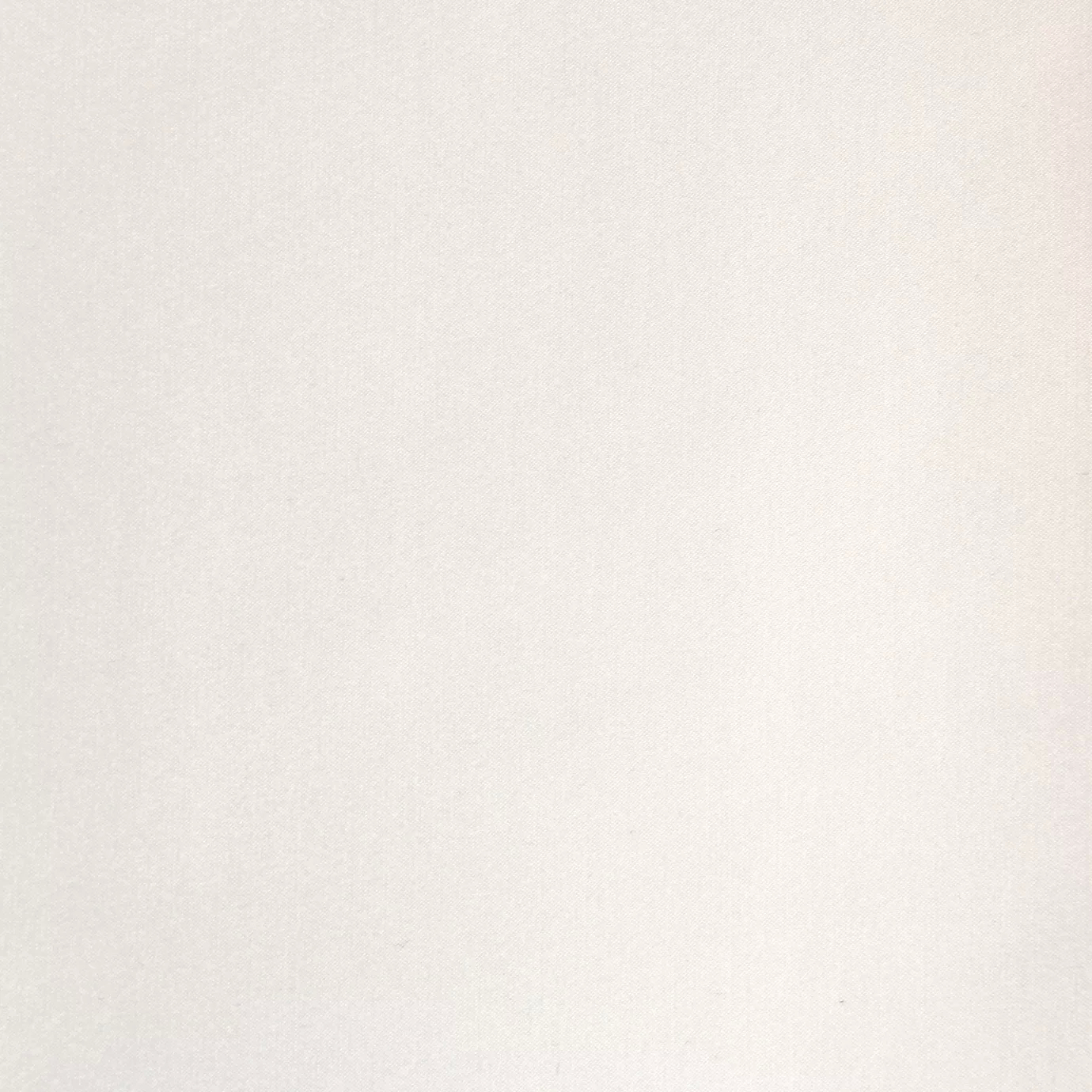 Soft close-up of a Satina Lux Pure White fabric swatch in a pure and elegant white tone, showcasing its smooth texture and a subtle sheen that gives it a feeling of sophistication and luminosity.