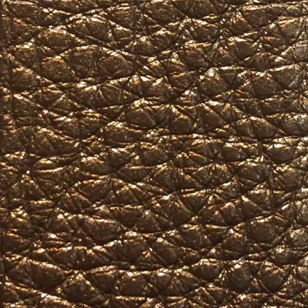 Close-up of a Harbor Antique Gold fabric swatch in a textured, antique gold tone, showcasing its raised areas and grooves that give it a vintage and elegant feel. The soft sheen highlights the depth of its texture.