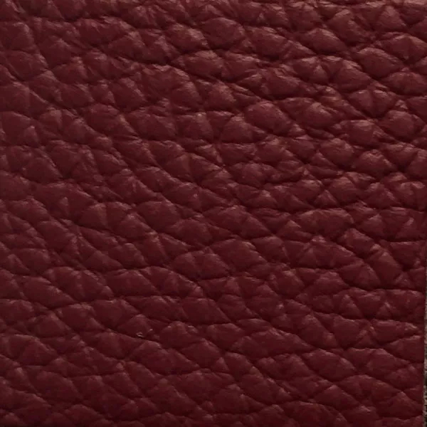 Close-up of a Harbor Apple Butter fabric swatch in a soft reddish-brown tone with texture, showcasing its raised areas and grooves that give it a natural and elegant feel. The soft sheen highlights the depth of its texture.