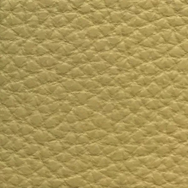Close-up of a Harbor Cedar fabric swatch in a light yellowish-beige tone with texture, showcasing its raised areas and grooves that give it a natural and elegant feel. The soft sheen highlights the depth of its texture.