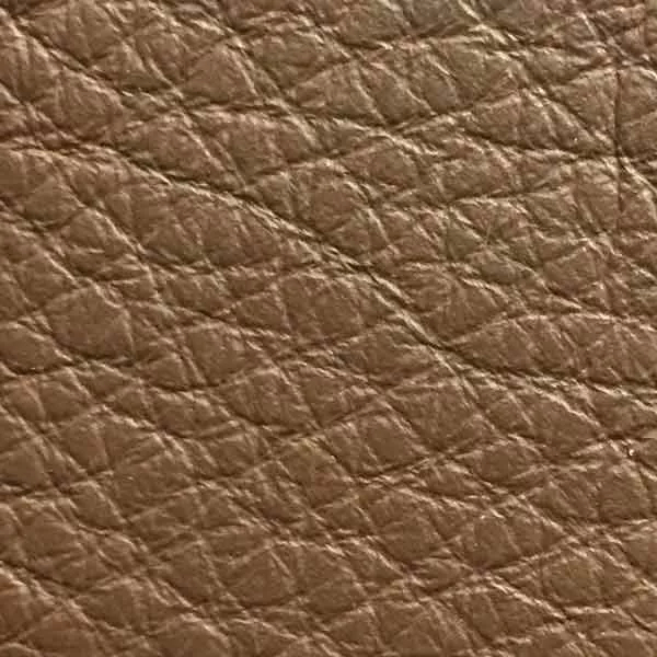 Close-up of a Harbor Nutmeg fabric swatch in a warm nutmeg brown tone with texture, showcasing its raised areas and grooves that give it a natural and elegant feel. The soft sheen highlights the depth of its texture.