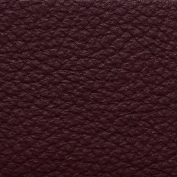 Close-up of a Harbor Ruby Wine fabric swatch in a deep ruby red tone with texture, showcasing its raised areas and grooves that give it a natural and elegant feel. The soft sheen highlights the depth of its texture.