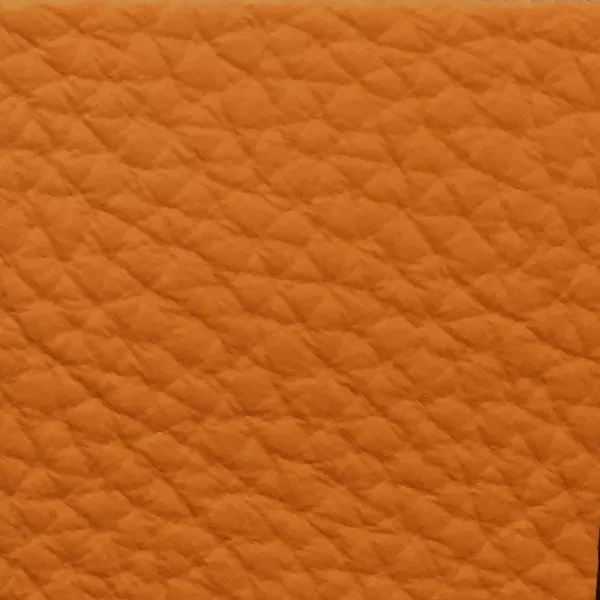 Close-up of a Harbor Tangerine fabric swatch in a vibrant tangerine orange tone with texture, showcasing its raised areas and grooves that give it a cheerful and elegant feel. The soft sheen highlights the depth of its texture.