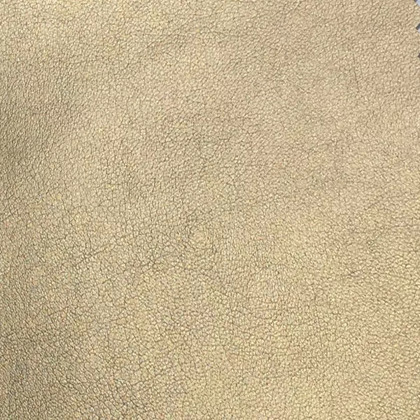 A close-up of Komodo 12428 Synthetic Leather shows a fine, slightly raised texture with subtle variations in a soft, light gold.