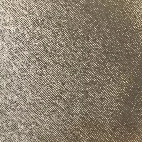 A close-up of Nomad Synthetic Leather in a soft, light tan reveals a fine, diagonal cross-hatch texture with subtle variations.