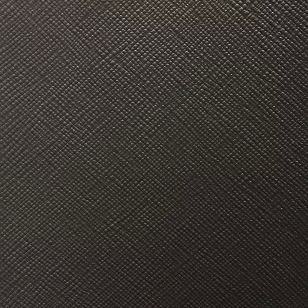 A detailed view of Nomad Synthetic Leather in a very dark brown, almost black, shows a fine, diagonal cross-hatch texture.