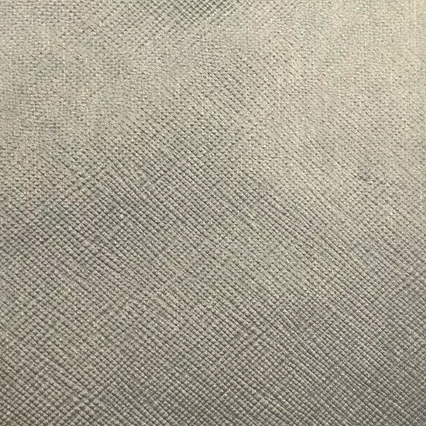 A close-up of Nomad Synthetic Leather shows a finely textured surface with a subtle, diagonal cross-hatch pattern in a light gray.