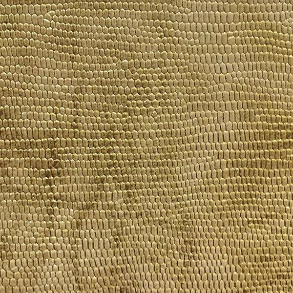 A detailed close-up of Ofidia Gold Synthetic Leather shows a textured, repeating pattern resembling reptile scales in a rich, metallic gold tone.
