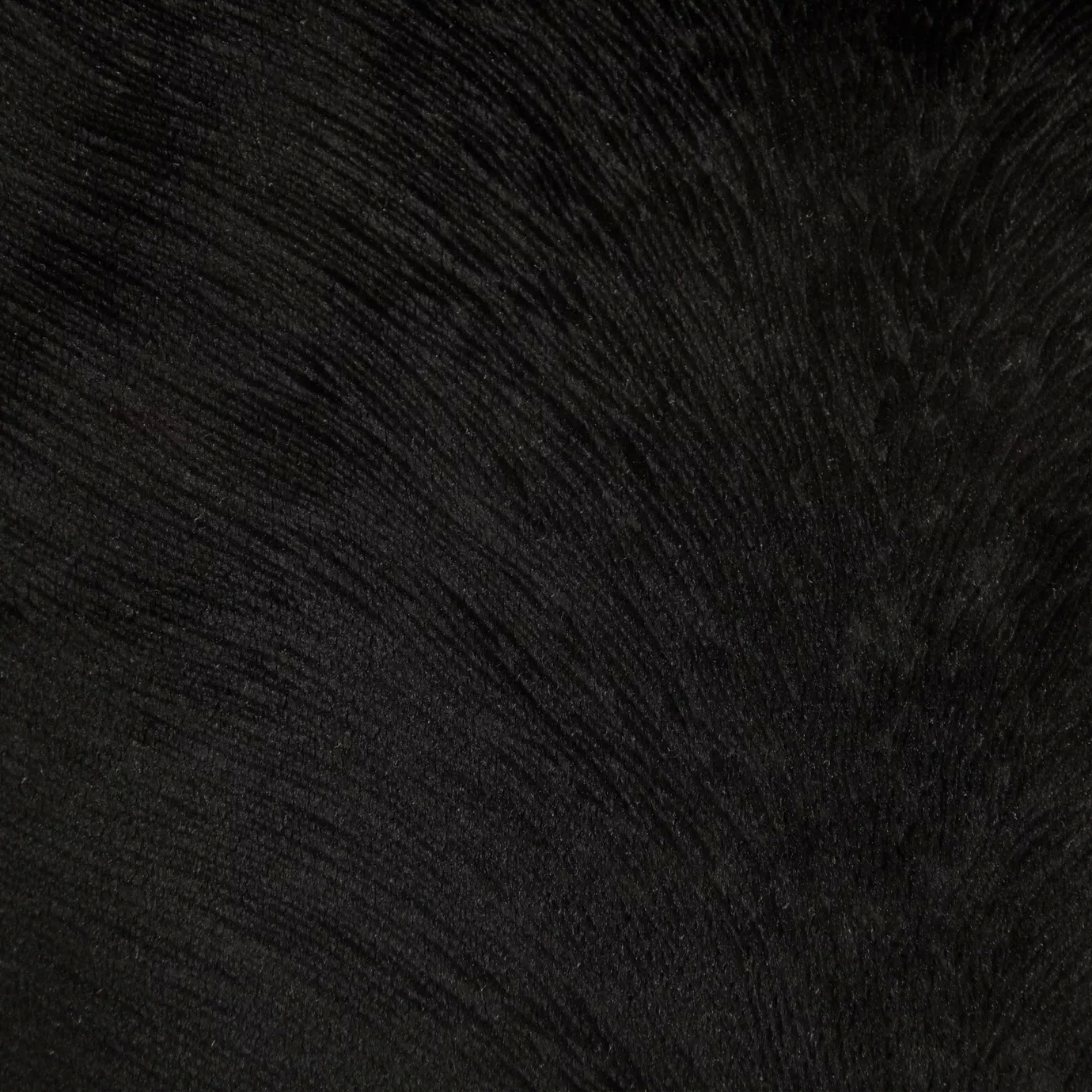 A close-up of deep black, subtly textured Hide Velvet 099 fabric.