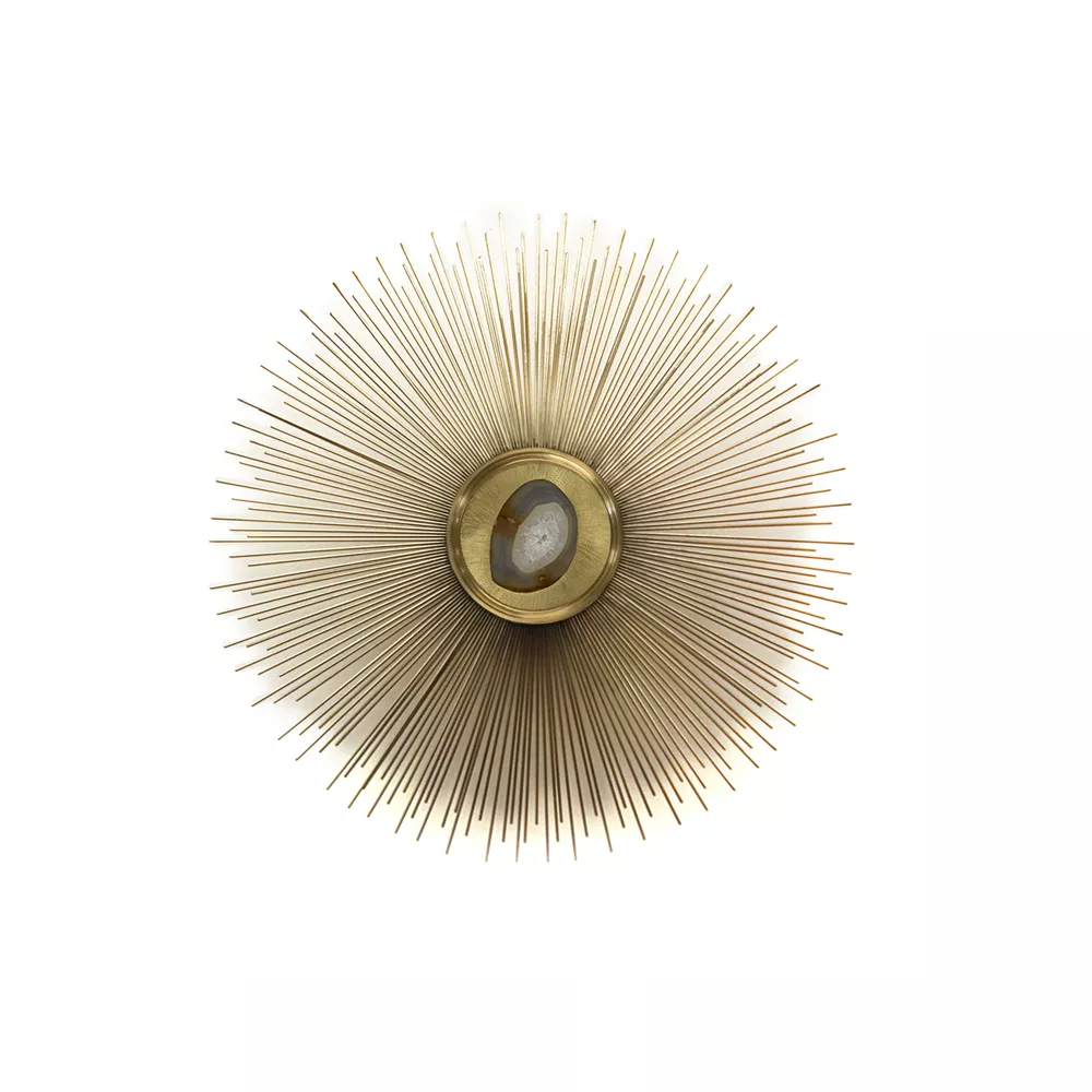 Sconce in which the light passes through an agate and with a metallic structure of rays.