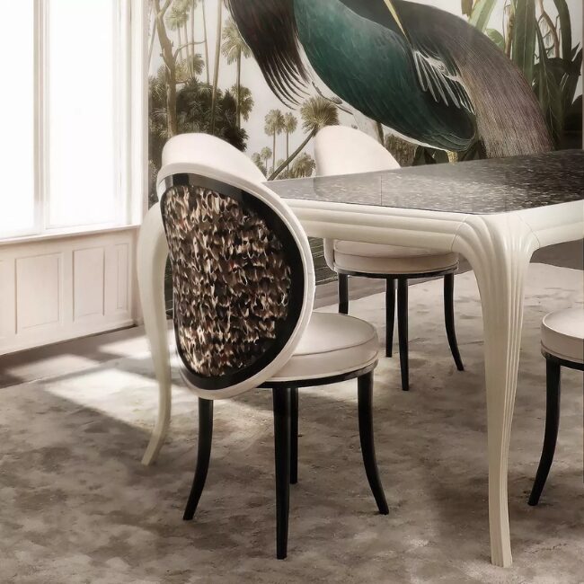 Merveille Folie Feather Back Dining Chair: featuring a neutral colored strucuture, with a black frame and cream upholstery, this chair stands out for its feather adorned backrest.