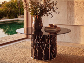 the story behind the enchanted collection by koket - enchanted branch metal handmade table in a beautiful stone foyer setting with a pool in the background
