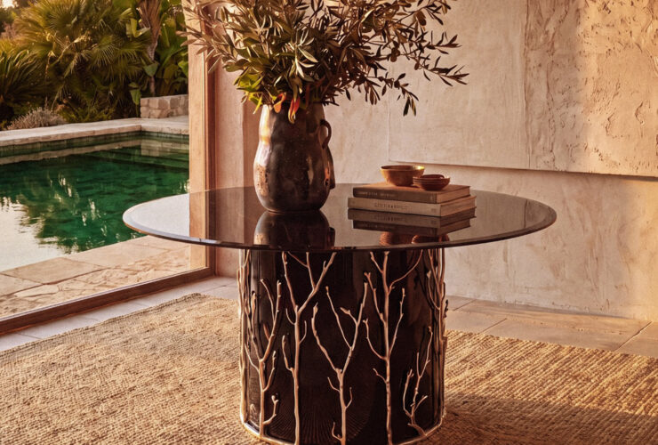 the story behind the enchanted collection by koket - enchanted branch metal handmade table in a beautiful stone foyer setting with a pool in the background