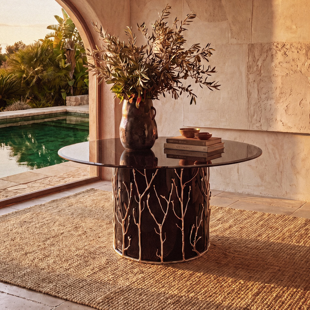 the story behind the enchanted collection by koket - enchanted branch metal handmade table in a beautiful stone foyer setting with a pool in the background